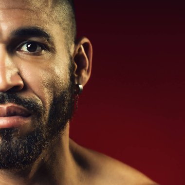 Yüzü sakallı ve kulağında küpe olan Kübalı bir adam. Stüdyo resmi