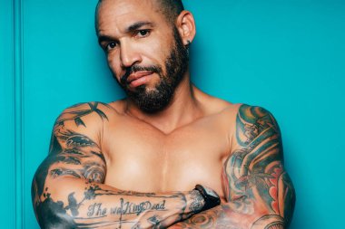 Esmer, vahşi bir adam. Dövmeli çıplak kaslı vücut. Bir Kübalı veya Latin 'in Stüdyo portresi.