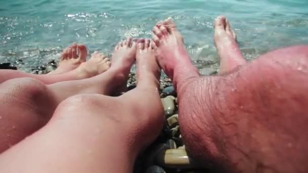 To są nagie stopy rodziny w falach morskich na kamiennym brzegu.. — Wideo stockowe