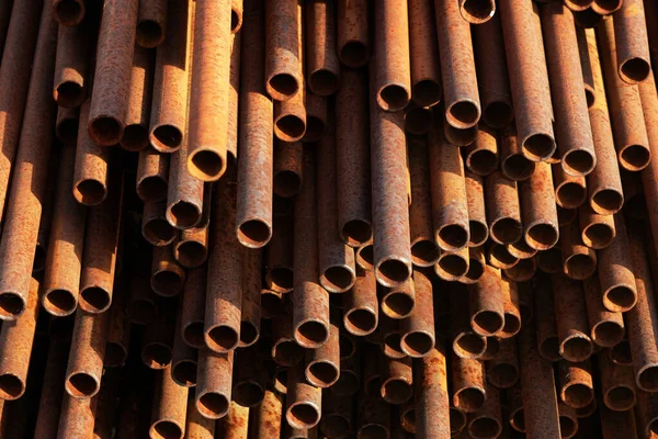 Muitos tubos de metal de pequeno diâmetro para gaseificação e construção encontram-se em uma pilha em um armazém aberto na rua. — Fotografia de Stock
