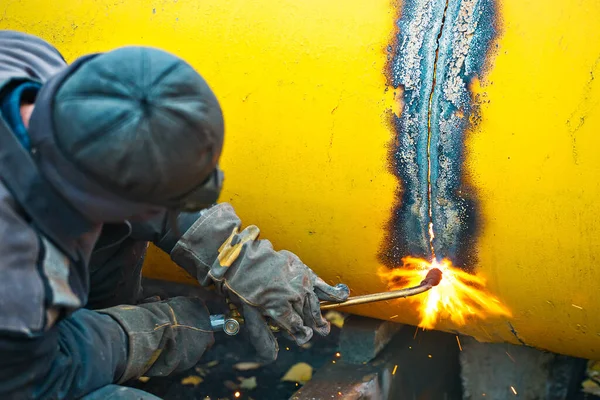 焊机用乙炔焊接切割一个大的黄色管，用于气化。处置旧的旧金属管. — 图库照片
