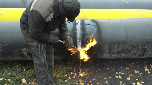 Le soudeur coupe un gros tuyau avec soudage à l'acétylène pour la gazéification. Élimination des vieux tuyaux métalliques usagés. — Video