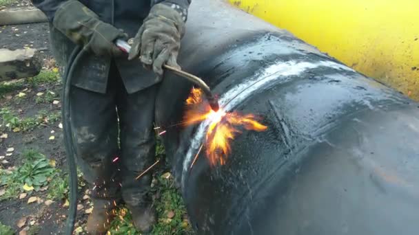 Il saldatore taglia un grande tubo con saldatura in acetilene per la gassificazione. Smaltimento di vecchi tubi metallici usati. — Video Stock