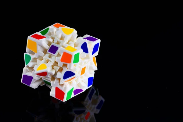 Ceci est un cube avec des visages colorés puzzle sur un fond sombre avec réflexion. Un jeu pour le développement de la pensée — Photo