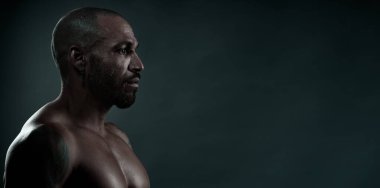 Siyah arka planda Afrikalı bir adamın profil portresi. Çıplak gövdeli güçlü ve kaslı Kübalı. Yan görünüm.