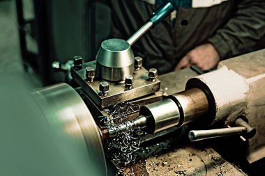 Mekanik atölyesinde keski ve metal talaşı olan torna parçası. Fabrikadaki üretim salonunda gerçek iş akışı..