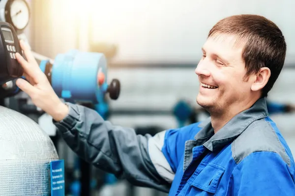 Manlig ingenjör i arbete uniform kontrollerar avläsningar av enheter vid produktionsanläggningen och skrattar. Glada och glada arbetare. — Stockfoto