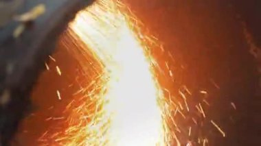 Metal öğütücü. Video bir metal boru kesti ve kıvılcımlar uçuşmaya başladı. Endüstriyel geçmiş. Özürlü hareket. 