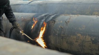 İşyerindeki kaynakçı metal boruları kesiyor. Gaz boru hattının tamiri. Sahnelenmemiş gerçek video. 