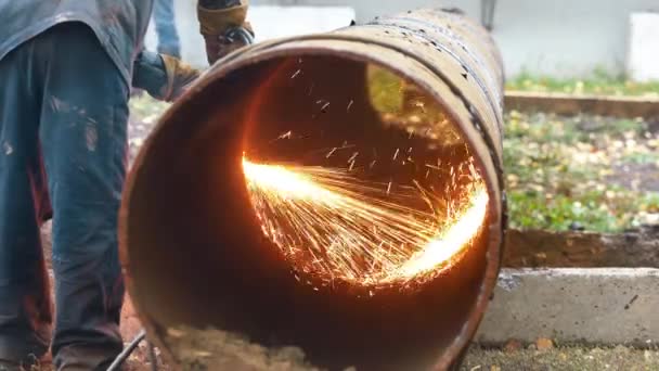 Il saldatore taglia un tubo metallico di grande diametro e scintille volare. — Video Stock