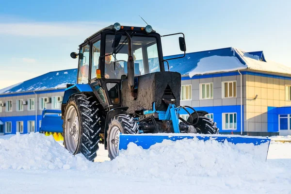 Tractor con pala limpia calles de nieve. Servicio de retirada y remoción de nieve en invierno. Flujo de trabajo de escena real. — Foto de Stock