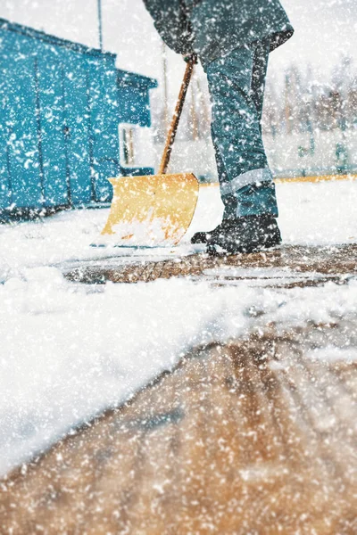 El conserje limpia el área de nieve con una pala de madera. Limpieza de calles después de nevadas y ventiscas. — Foto de Stock