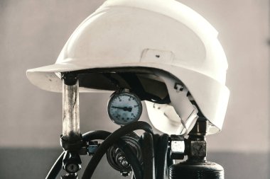 İnşaat miğferi kaynakçıda oksijen tüpüne takılır. Sanayi ve inşaat.