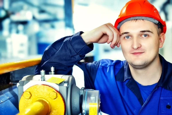 Retrato de joven ingeniero en casco en el entorno de trabajo en la factoría. trabajador de gas con confianza mira directamente a la cámara — Foto de Stock