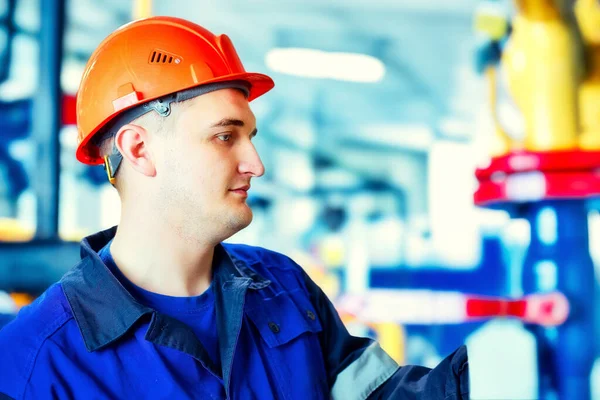 气体加工厂工作时戴头盔的工程师的画像.工人检查设备。能源和气化. 图库照片