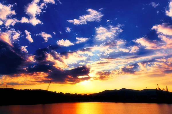 Morgenochtend in de haven. Kalme zee in de baai voor zonsopgang. Kleurrijke haven achtergrond. Dramatische hemel met wolken — Stockfoto