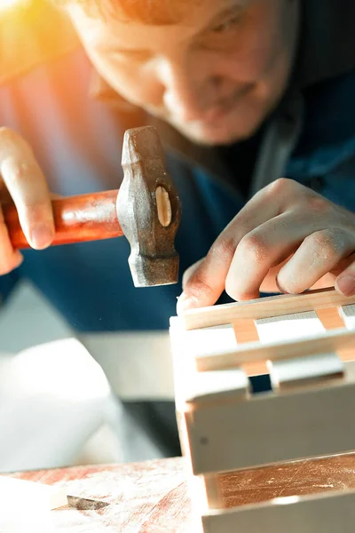 İş kıyafetleri içindeki genç beyaz marangoz marangozluk atölyesinde ahşap kutular yapıyor. Gerçek sahne. Küçük işletme — Stok fotoğraf