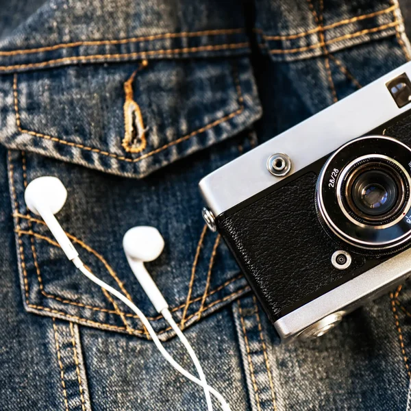 필름 카메라 와 흰 유선 헤드폰 은 데님 을 배경으로 놓여 있다. 유행하는 히프 스터 배경. 역 스타일. — 스톡 사진