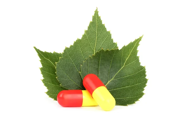 Pills closeup with three leaves — Stock Photo, Image