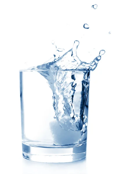 Lód w szklankę wody z splash — Zdjęcie stockowe
