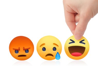 Kiev, Ukrayna - 18 Şubat 2021: Kadın eli ve Facebook logosu ile Empatik Emoji Reaksiyonları gibi bir kavram seçmek