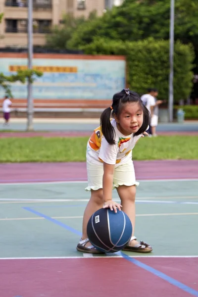Ejercitando poco linda chica con baloncesto — Foto de Stock