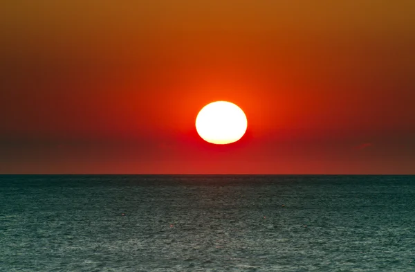 Zon onder zonsondergang over zee — Stockfoto