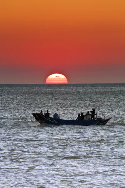 Рибальський човен на заході сонця над морем — стокове фото