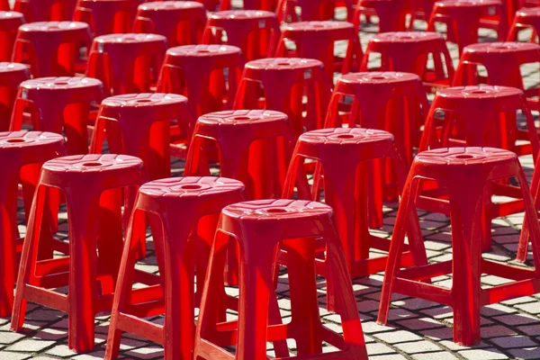 Пустые красные пластиковые стулья — стоковое фото