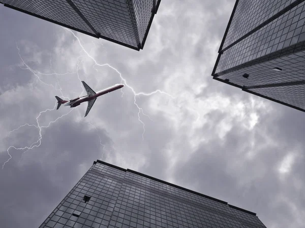 Bottom view of airplane flying above skyscraper — Stock Photo, Image