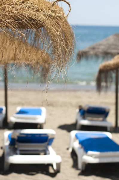 Parapluies de plage et chaises longues en paille — Photo