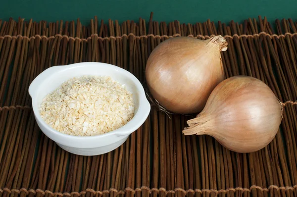 Mature onion and bowl with dried onion powder — Stock Photo, Image