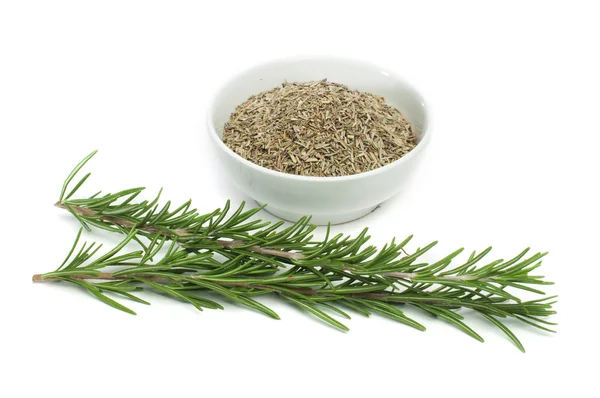 Fresh rosemary and a bowl with dried — Stock Photo, Image