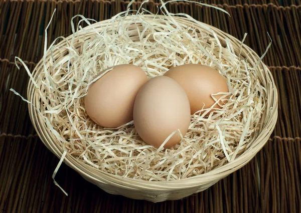 Raw eggs in a wicker basket — Stock Photo, Image