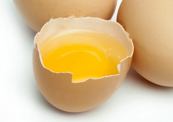 Tree whole eggs and another broken in half raw egg — Stock Photo, Image