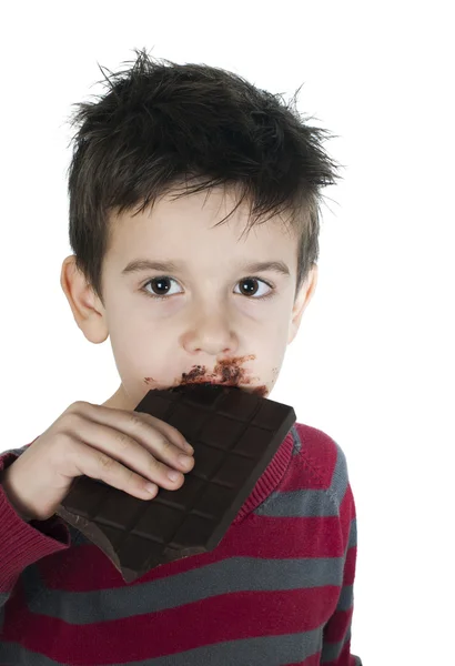 Усміхнений маленький хлопчик їсть шоколад — стокове фото