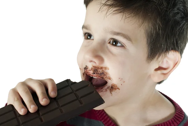 Smiling little boy eating chocolate — Stock Photo, Image