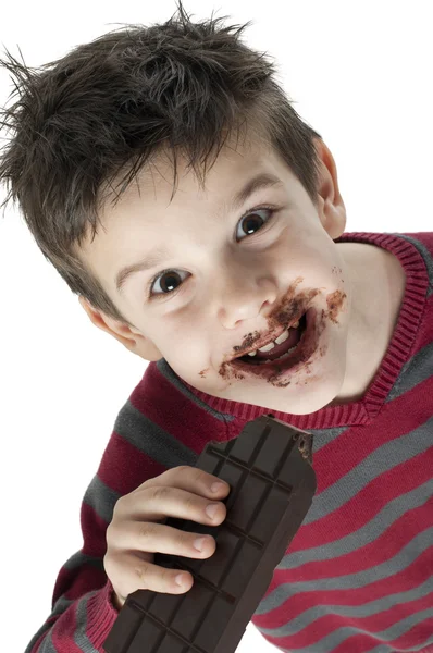 Smiling little boy eating chocolate — Stock Photo, Image