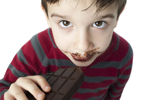 Petit garçon souriant mangeant du chocolat — Photo