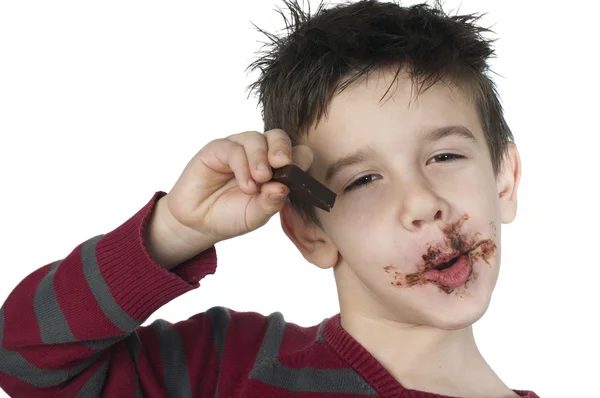 Lachende jongetje eten van chocolade — Stockfoto