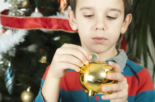 Pequeño niño pone una moneda en efectivo cerdo —  Fotos de Stock