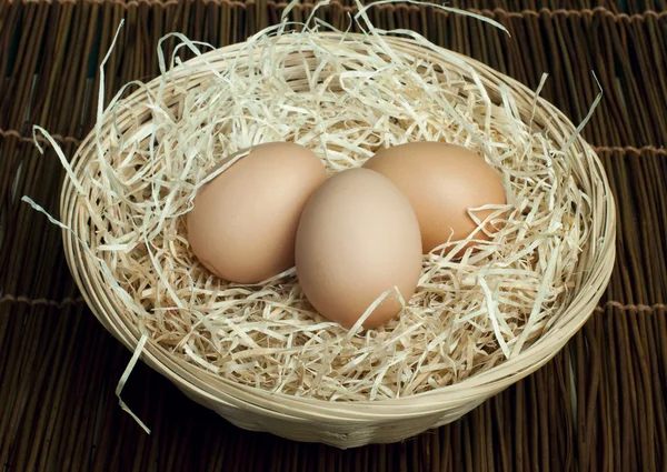 Raw eggs in a wicker basket Stock Image