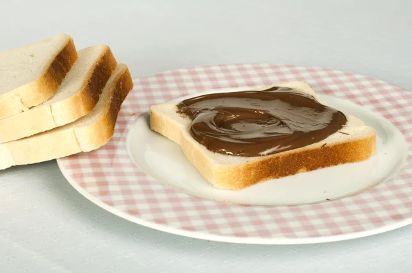 Chocolate líquido en una rebanada de pan — Foto de Stock