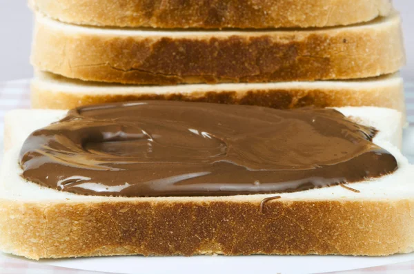 Liquid chocolate on a slice of bread — Stock Photo, Image