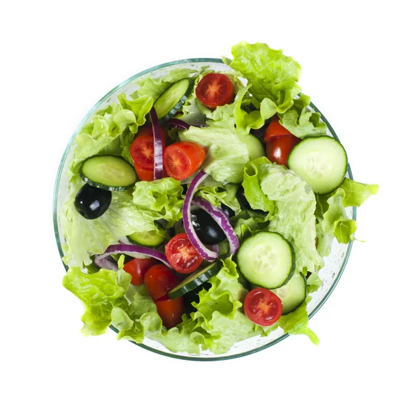 Salada em uma tigela de vidro em um fundo branco — Fotografia de Stock