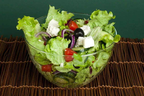 Salad in a glass bowl on a wooden base — Stok fotoğraf