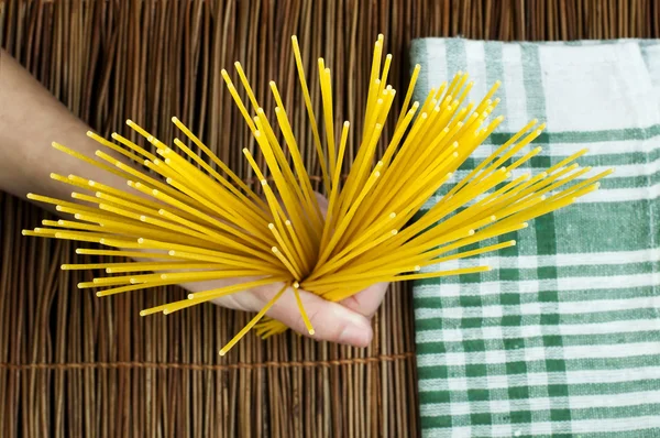 Female hand holding spaghetti — Stock Photo, Image