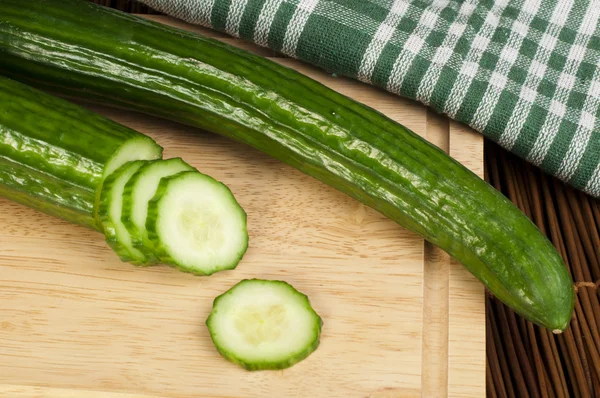 Sliced cucumber on a wooden board — Stock Photo, Image