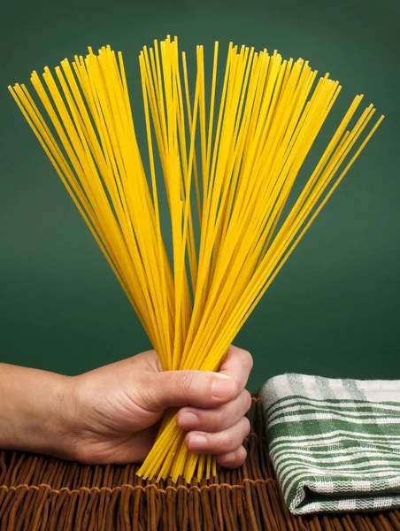 Female hand holding spaghetti — Stock Photo, Image