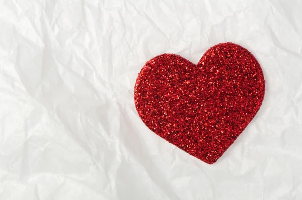 Shiny red heart on white paper — Stock Photo, Image